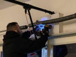 Rainbow Garage Door Service Tech repairing a garage door